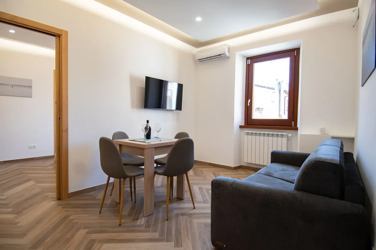 The living room at Finestra sul Borgo with sofa, dining table and window